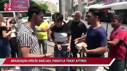 Arkadaşını direğe bağladı, parayla tokat attırdı