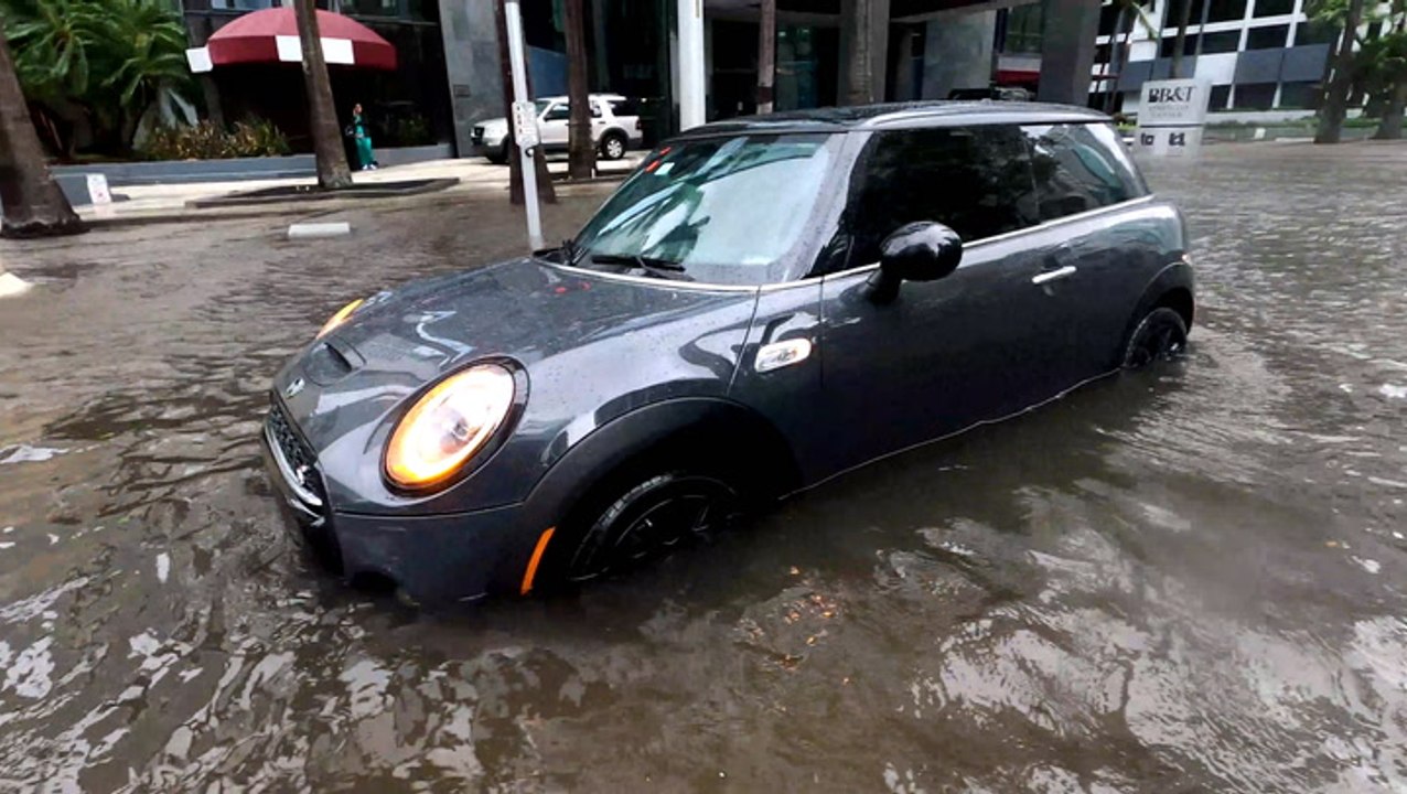 Cars plow through flooded streets of Miami