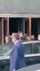 Un escolta de Sánchez muestra su arma a los manifestantes que protestan a la salida del presimiente de un acto