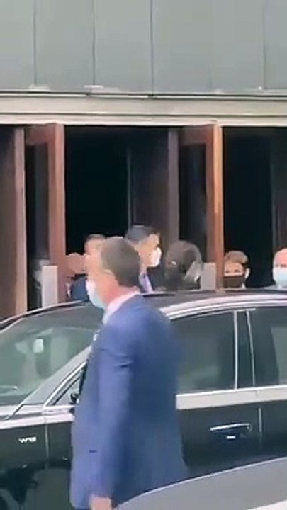 Un escolta de Sánchez muestra su arma a los manifestantes que protestan a la salida del presimiente de un acto