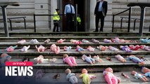 Activists lay dolls at Treasury to protest cuts to Britain's aid budget