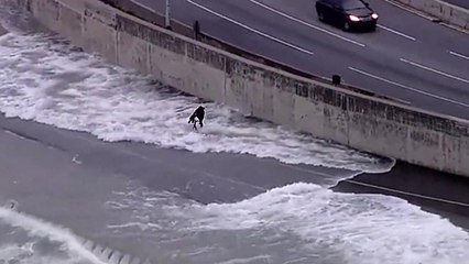 Un cycliste se prend des vagues