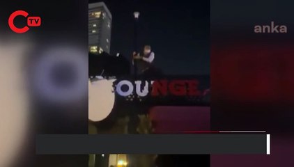 Kısıtlamaya tepki gösteren esnaf, çatıya çıktı, tabelayı parçaladı