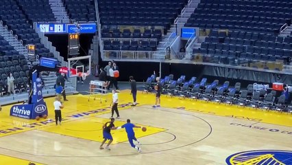 Stephen Curry recule dans les tribunes pour son tir d'avant-match