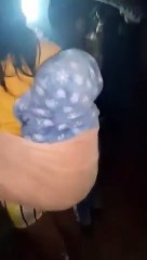 Elle se rend à un concert avec son enfant sur le dos et une bouteille de bière à la main