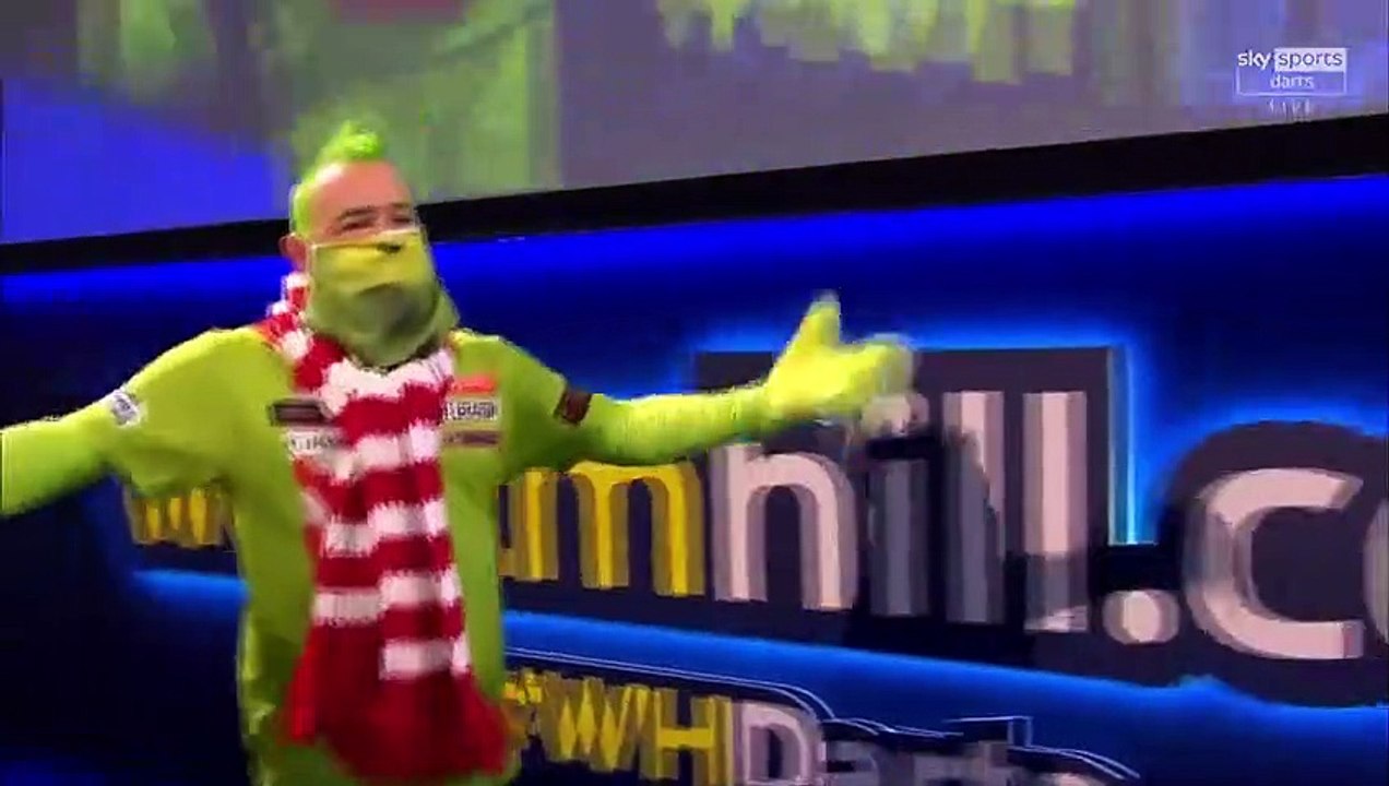 Le champion du monde Peter Wright sort pour son match aux championnats de fléchettes habillé en Grinch