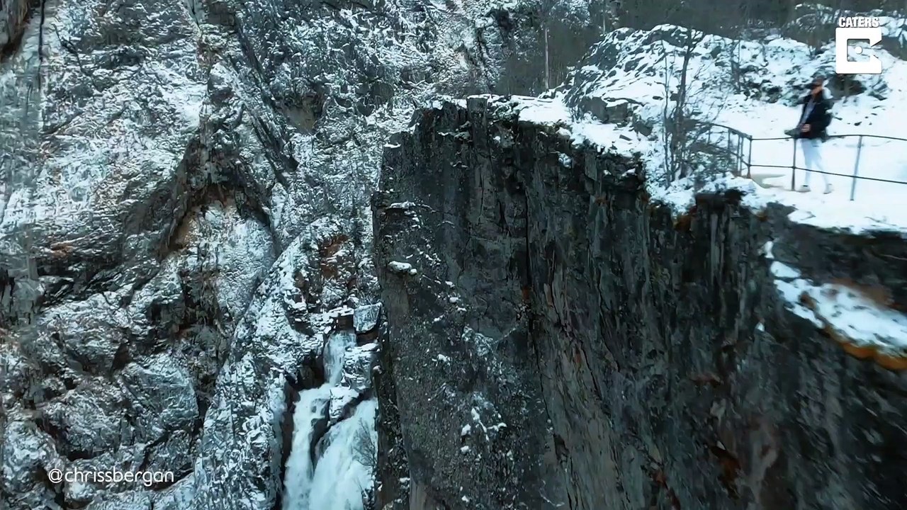 Ce drone plonge d'une falaise et longe une casc...