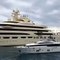 Un yacht de luxe navigue à côté d'un immense yacht de milliardaire