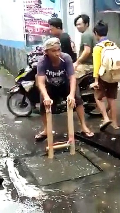 Un homme plonge sans aucun équipement dans une bouche d’égout inondée