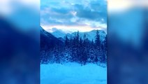 Snow-covered mountains stand majestic under Alberta sunset