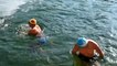 Swimmers dive into ice water despite record low temperatures