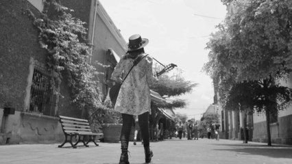 Lady Walking Down the Street While Playing Her Guitar