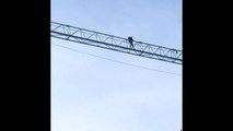 Un homme au sommet d'une grue près du pont des Trous