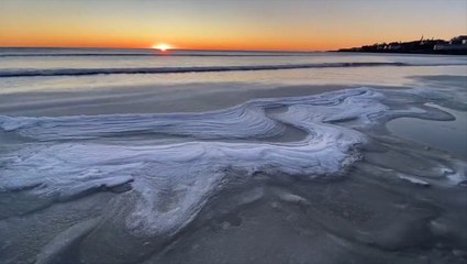 Sun rises over a windy, cold Maine beach