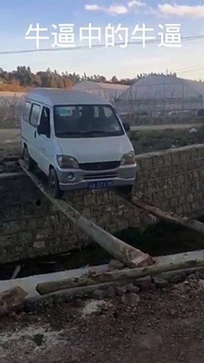 Une camionnette traverse sur deux troncs d'arbres