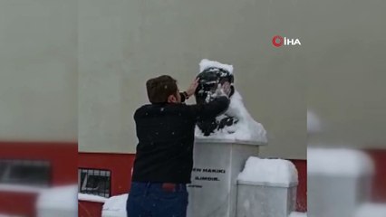Atatürk büstünün karlarını elleriyle temizledi