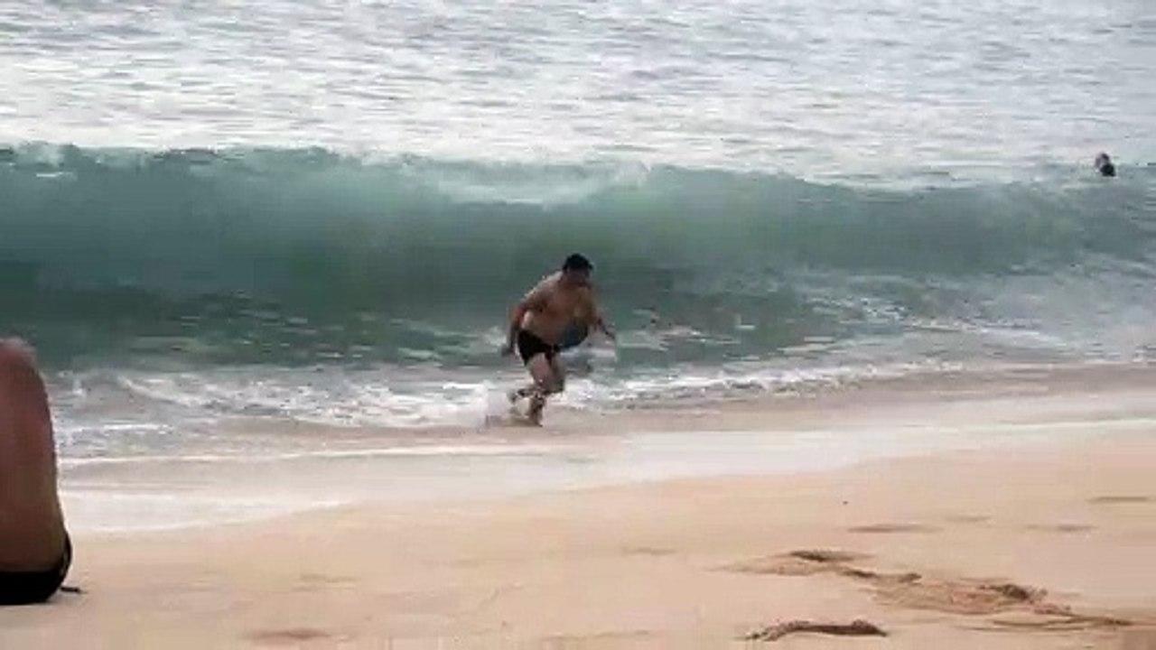 Man Runs Away While Woman Gets Hit By Wave