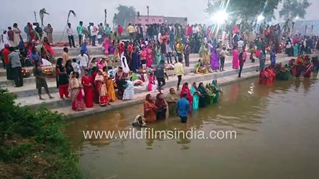 Chhat Puja on the banks of the Yamuna river_ women in colourful sarees dip into cold polluted river