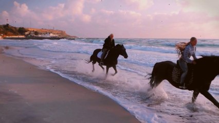 Romantic Couple Horse Riding on the Beach at Sunset