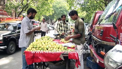 Mumbai street vendor with cart full of ripe Guavas - Customers, pedestrians and Fiat Padmini taxis