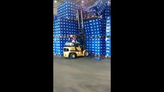 Hombre en la fábrica tirando torre de cervezas con toro mecanico