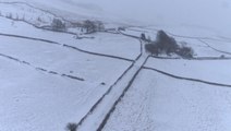 Fly over snow-covered landscapes in northern England