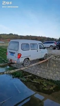 Une camionnette recule sur deux troncs d'arbres