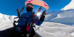 Man Paramotors While Skiing Over Snow Covered Mountains