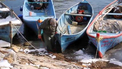 Kıyıları donan gölde balıkçıların buz kırma mesaisi