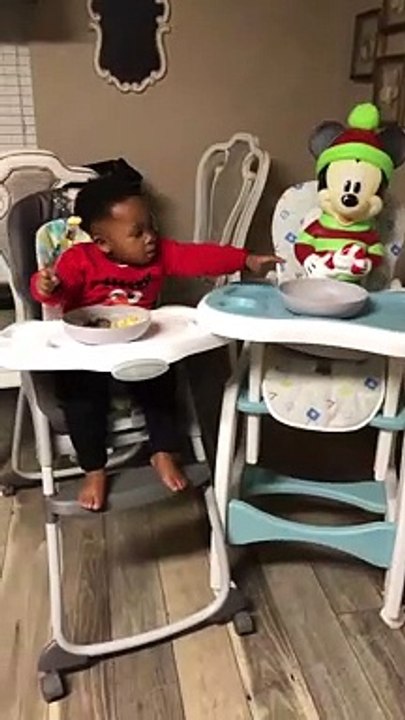 Ce petit enfant partage son repas avec mickey