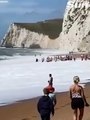 Incredible moment crowd forms human chain to rescue two swimmers from surf at Durdle Door