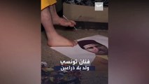 رسام تونسي يرسم لوحات بقدميه