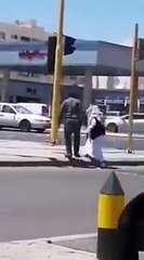 رجل امن يساعد مسنا لعبور أحد طرق المدينة