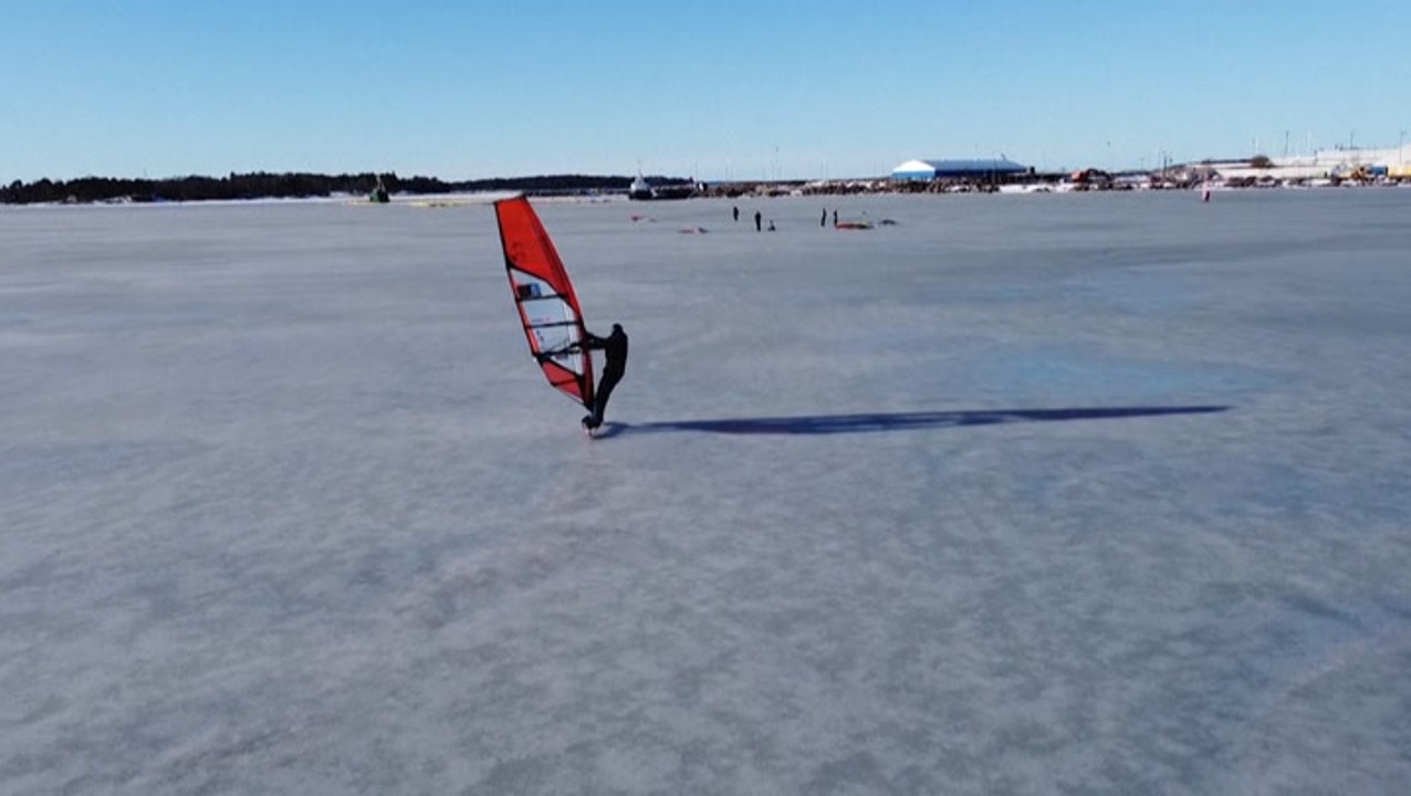 Windsurfers surf across frozen Baltic Sea
