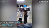 Mulher destrói televisão jogando boliche