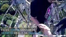Jovem se pendura em torre de altura impressionante