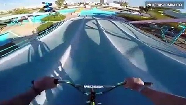 Jovem se aventura de BMX em tobogãs de parques aquáticos abandonados