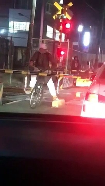 Ce cycliste pense être du bon coté de la barrière du passage à niveau alors que non... chanceux