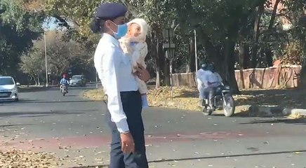VIDEO: बच्चे को गोद में लिए ड्यूटी कर रही महिला पुलिसकर्मी की हुई तारीफ, विभाग ने शुरू की जांच