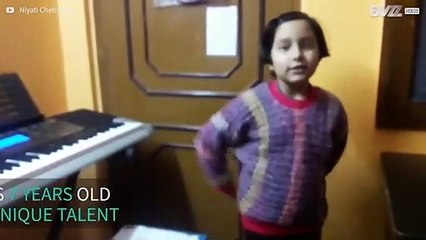 Seven-year old plays piano lying down and backwards