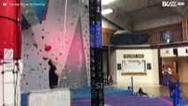 Boy shows off balancing skills by standing on huge plastic crate tower