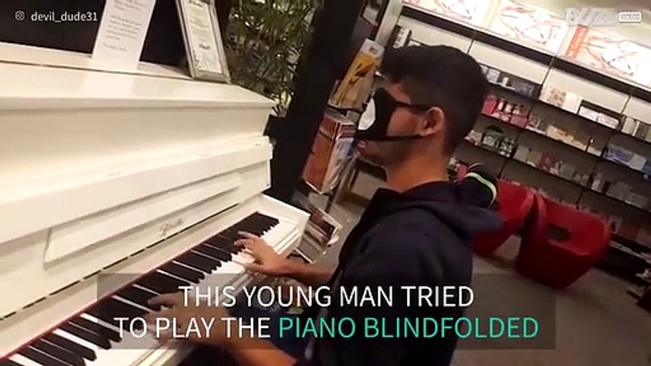 Young man plays the piano blindfolded