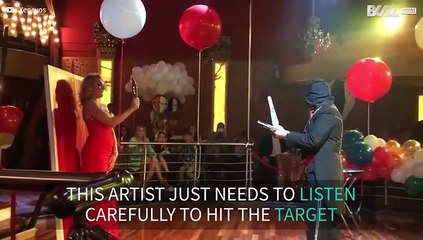 Blindfolded artist throws knives