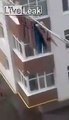 Woman cleaning her windows outside apartment 5 stories up