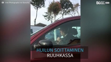Mies soittaa huilua helpottaakseen liikenteen aiheuttamaa stressiä