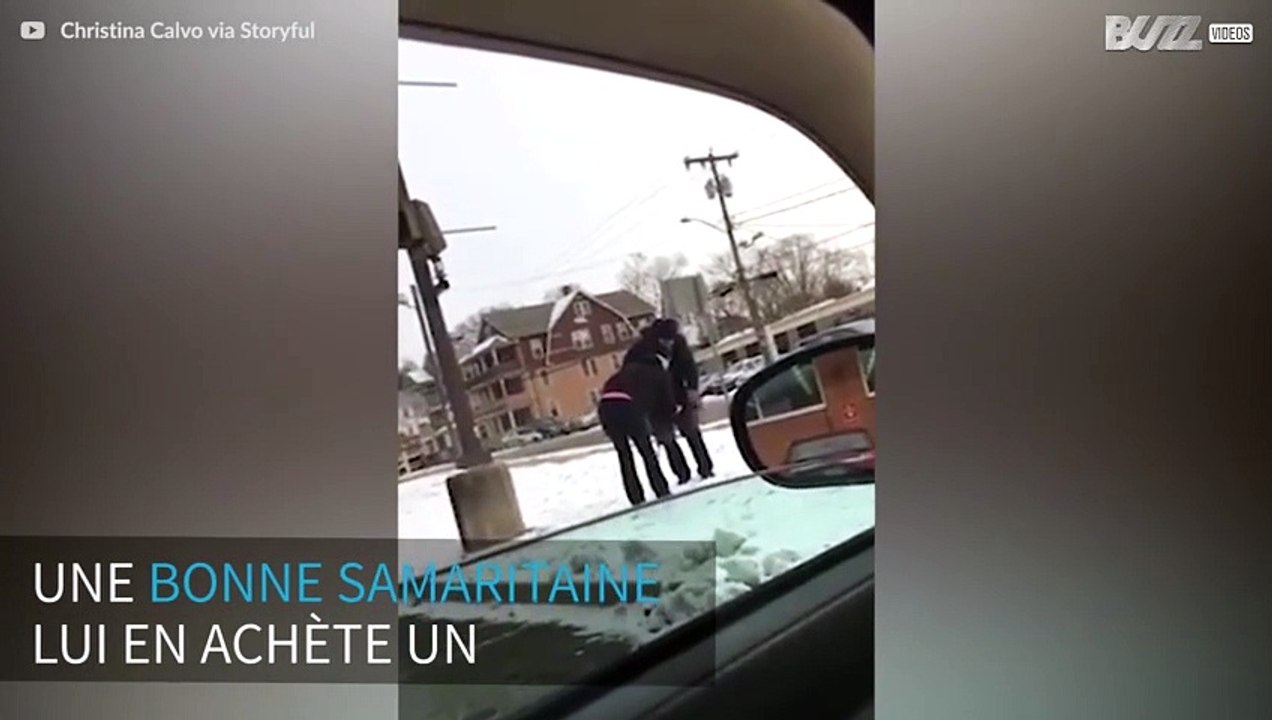Une femme offre un manteau à un SDF, après l'avoir vu dehors, dans le froid