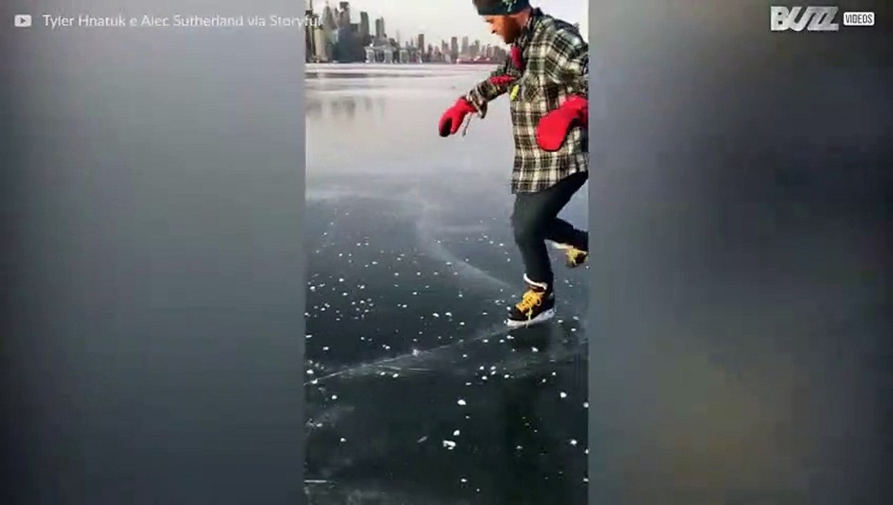 Un homme fait du patin à glacé sur un lac gelé