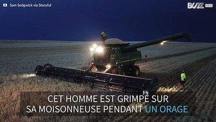 Un homme danse sur sa moissonneuse pendant un orage
