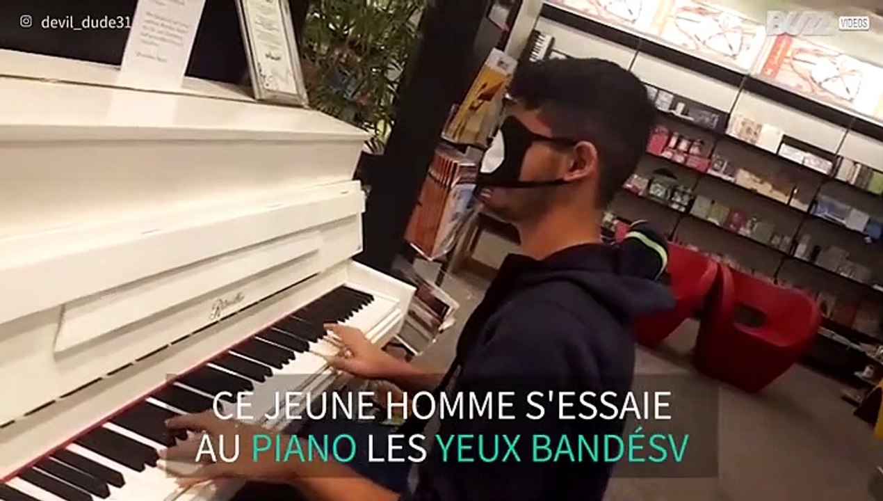 Un jeune homme joue du piano les yeux bandés