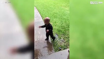 Ce garçonnet joue sous la pluie pour la première fois